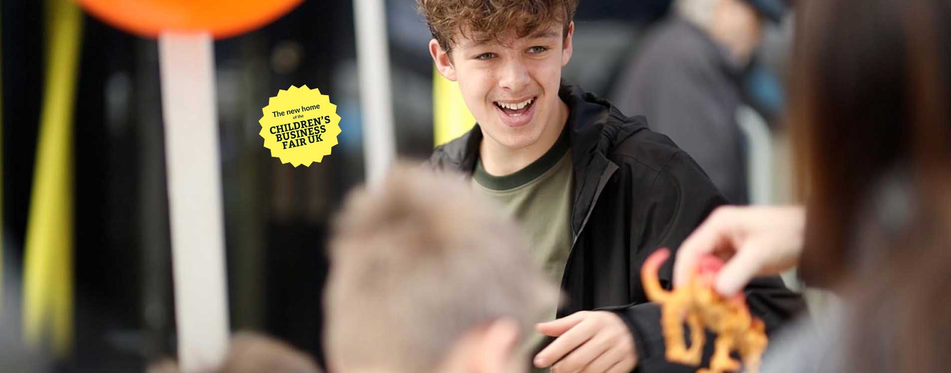 Young-entrepreneur-laughs-with-a-customer-at-the-Young-Business-Showcase_Badge