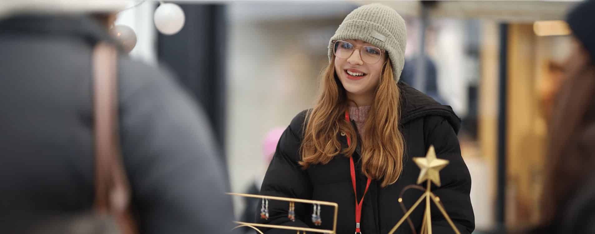 Young-entrepreneur-in-a-hat-sells-and-smiles-Young-Business-Showcase